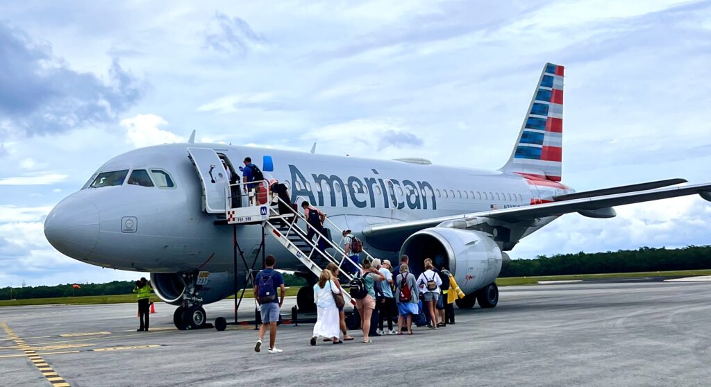 Passengers boarding an American Airlines plane with the aircraft visible in the background