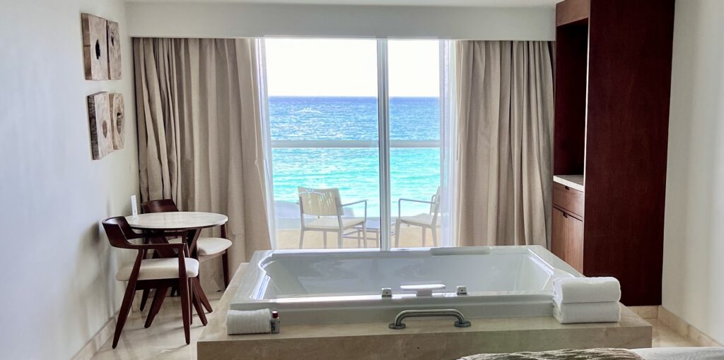 Elegant room at the all inclusive resorts : Sun Palace Cancun featuring a whirlpool tub with a stunning view of the Caribbean Sea, creating a serene and relaxing atmosphere.