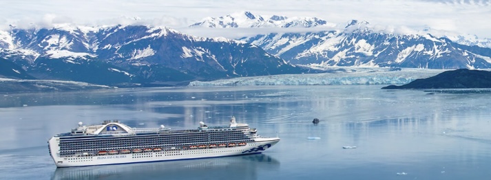 Princess Cruise ship navigating through Alaskan waters with majestic snow-capped mountains in the background