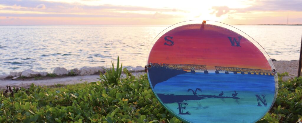 Sunset at Bahia Honda State Park with the Northeast, Southwest, Northwest, and Southeast directional art in the foreground, creating a picturesque and symbolic view