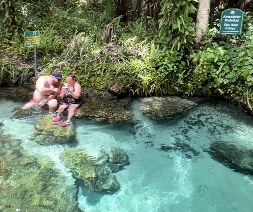 A couple enjoying the clear blue waters of Kelly Park Rock Springs, relaxing together in the peaceful spring setting