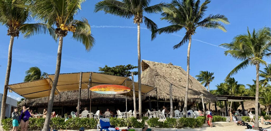 View of Lol-Ha Restaurant at the beach in Akumal, showcasing a coastal dining experience with palm trees