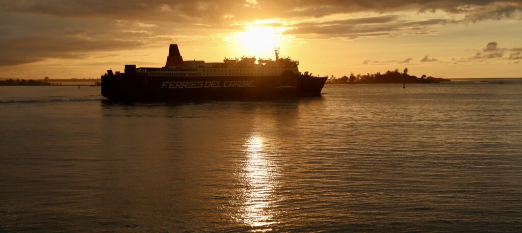 Cruise ship at sunset viewed from Castillo San Felipe del Morro in Old San Juan, Puerto Rico, with vibrant hues of orange, pink, and purple in the sky