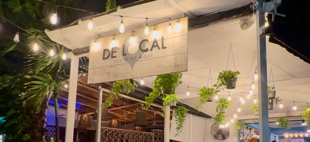 Del Local sign on 5th Avenue in Playa del Carmen, Mexico, showcasing a trendy spot in the heart of the Riviera Maya's bustling shopping and dining district.