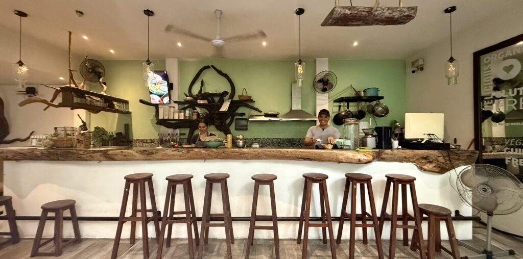 Cozy bar area at The Green Kitchen in Playa del Carmen, offering a relaxed atmosphere with fresh cocktails and a selection of drinks perfect for a casual outing at this restaurants bar